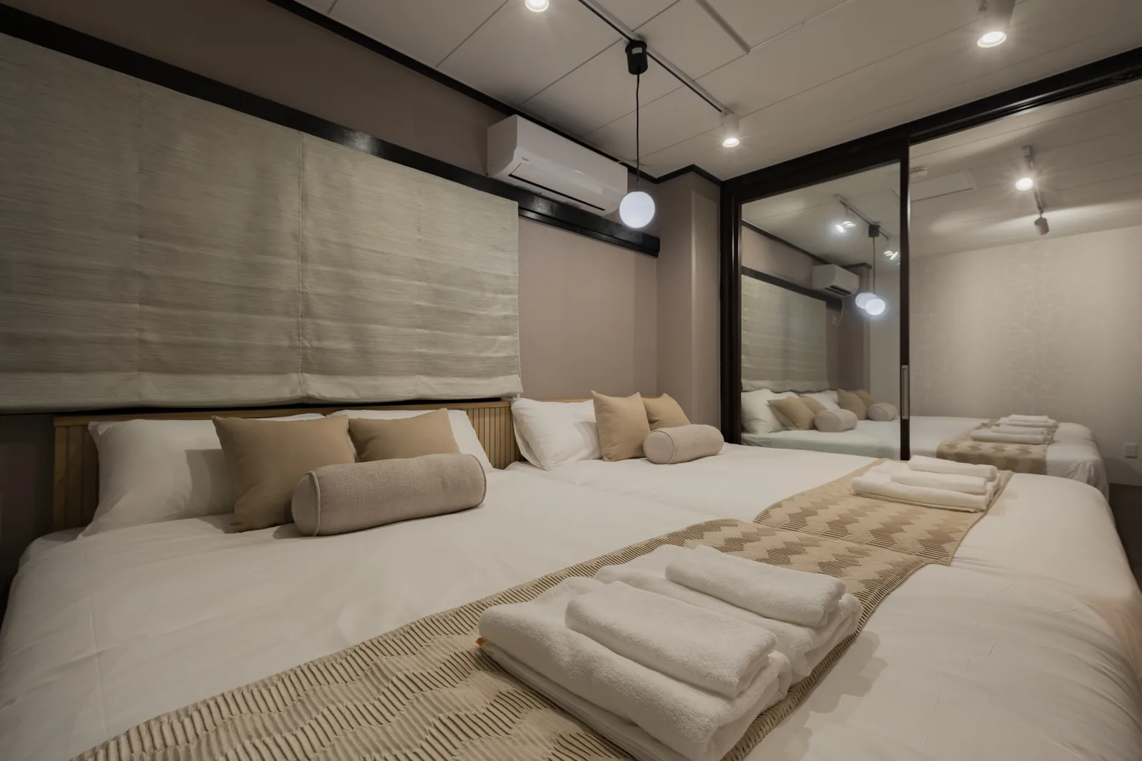 A bedroom with Simmons double beds and folded towels