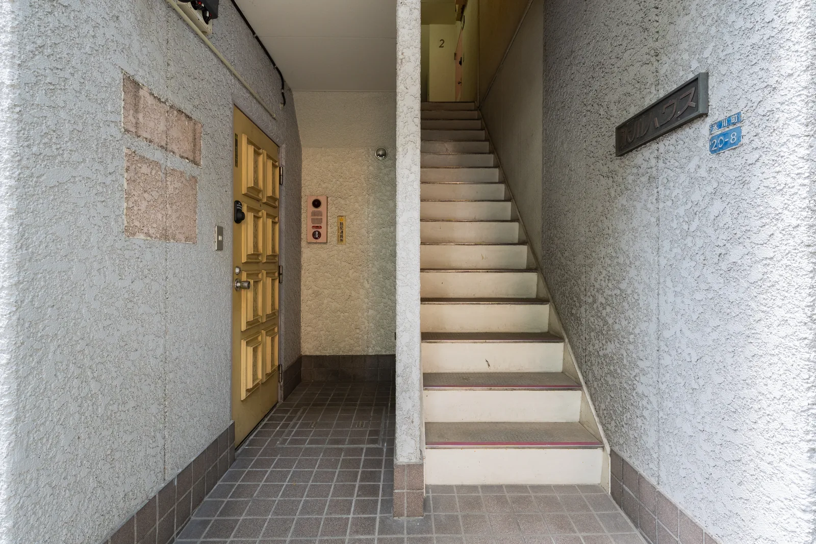The shared entrance and staircase between the two homes