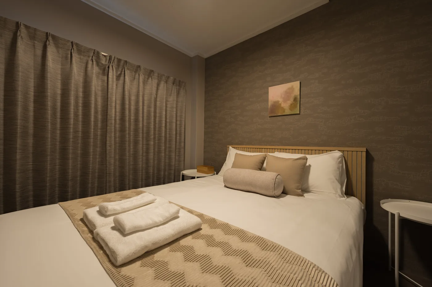 A bedroom in 101 with a Simmons double bed and folded towels
